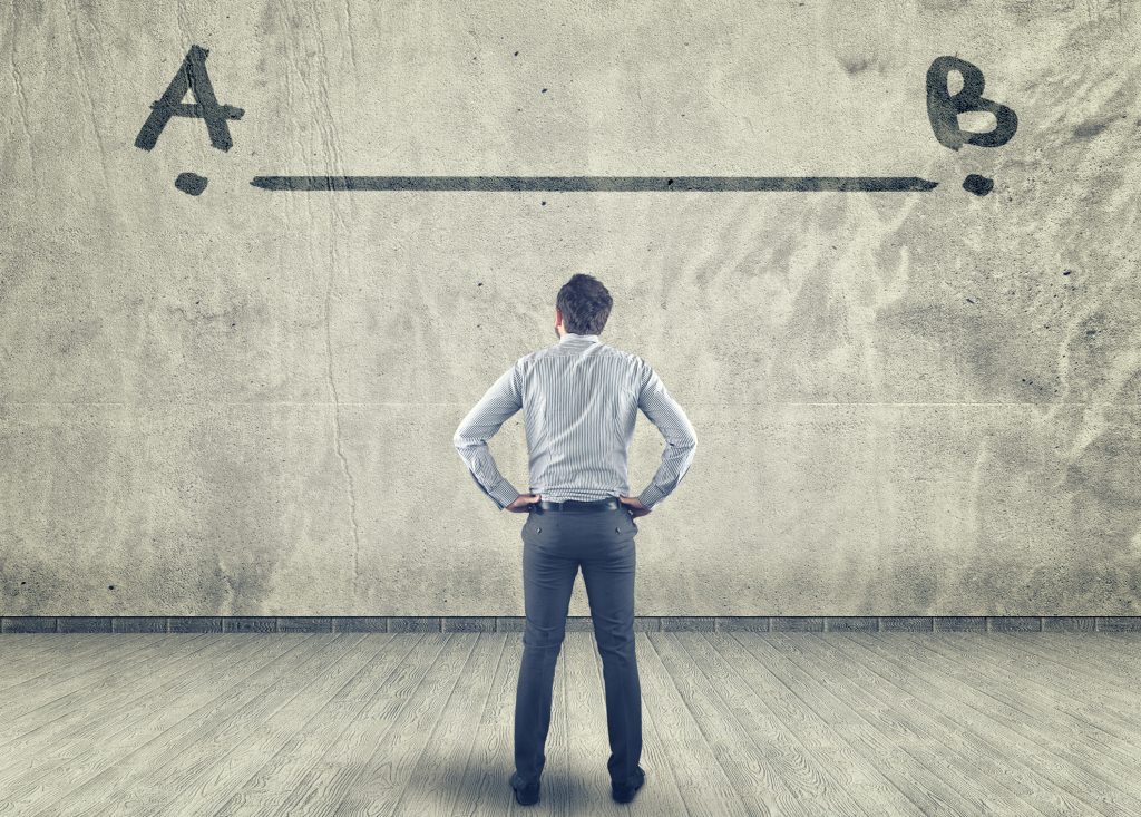 Businessman looking at a line between a to b painted on a wall