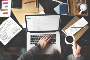 Person at computer drinking coffee