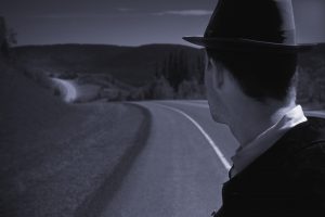 Man in hat looking down street