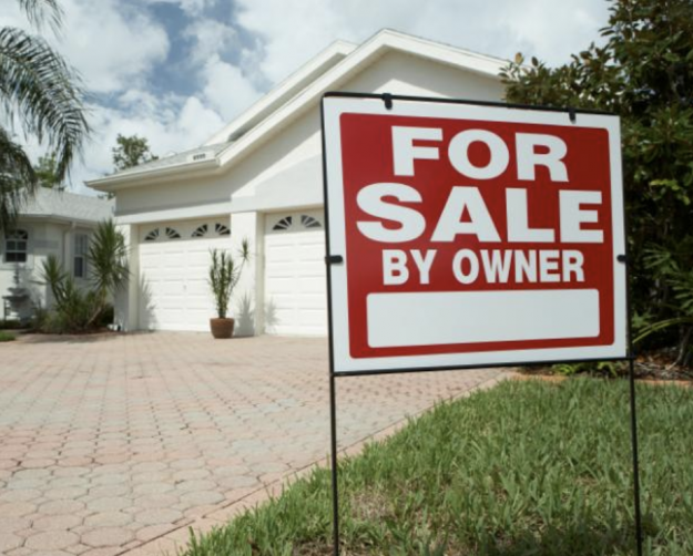 For sale by owner sign in front of house