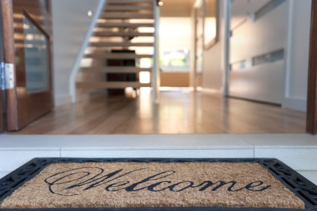 Welcome mat in front of beautiful home