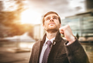 businessman looking up, fist up