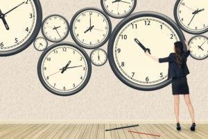 shutterstock_195499565 multiple clocks on wall, business woman