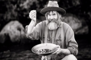 man panning for gold black and white photo