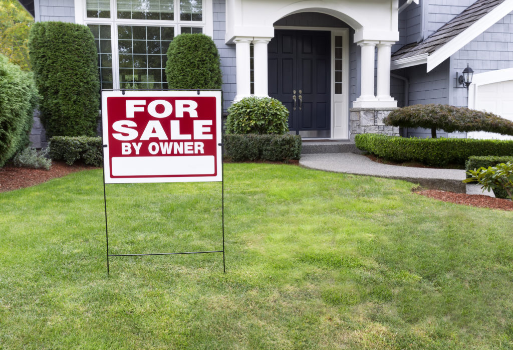 For sale by owner sign in front of house