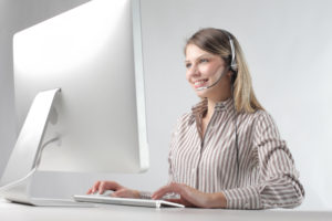 Female customer service with headset in front of computer