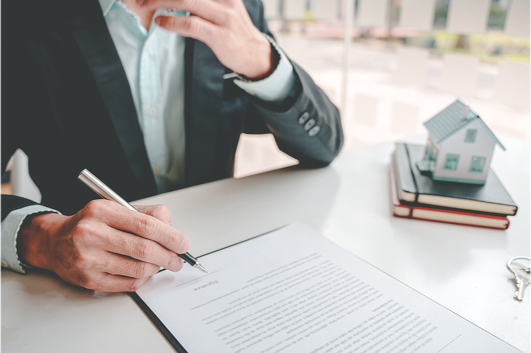 Realtor sitting at desk signing an expired listing letter with a fountain pen
