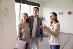 A female real estate agent showing an apartment to a young couple