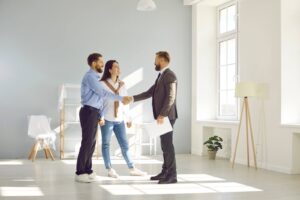 Real estate agent closing a deal A real estate agent closing a deal with young married couple