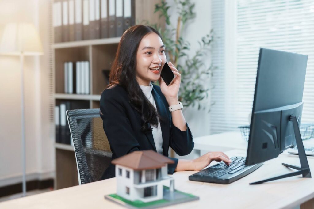 real estate agent talking on the phone and working on a computer