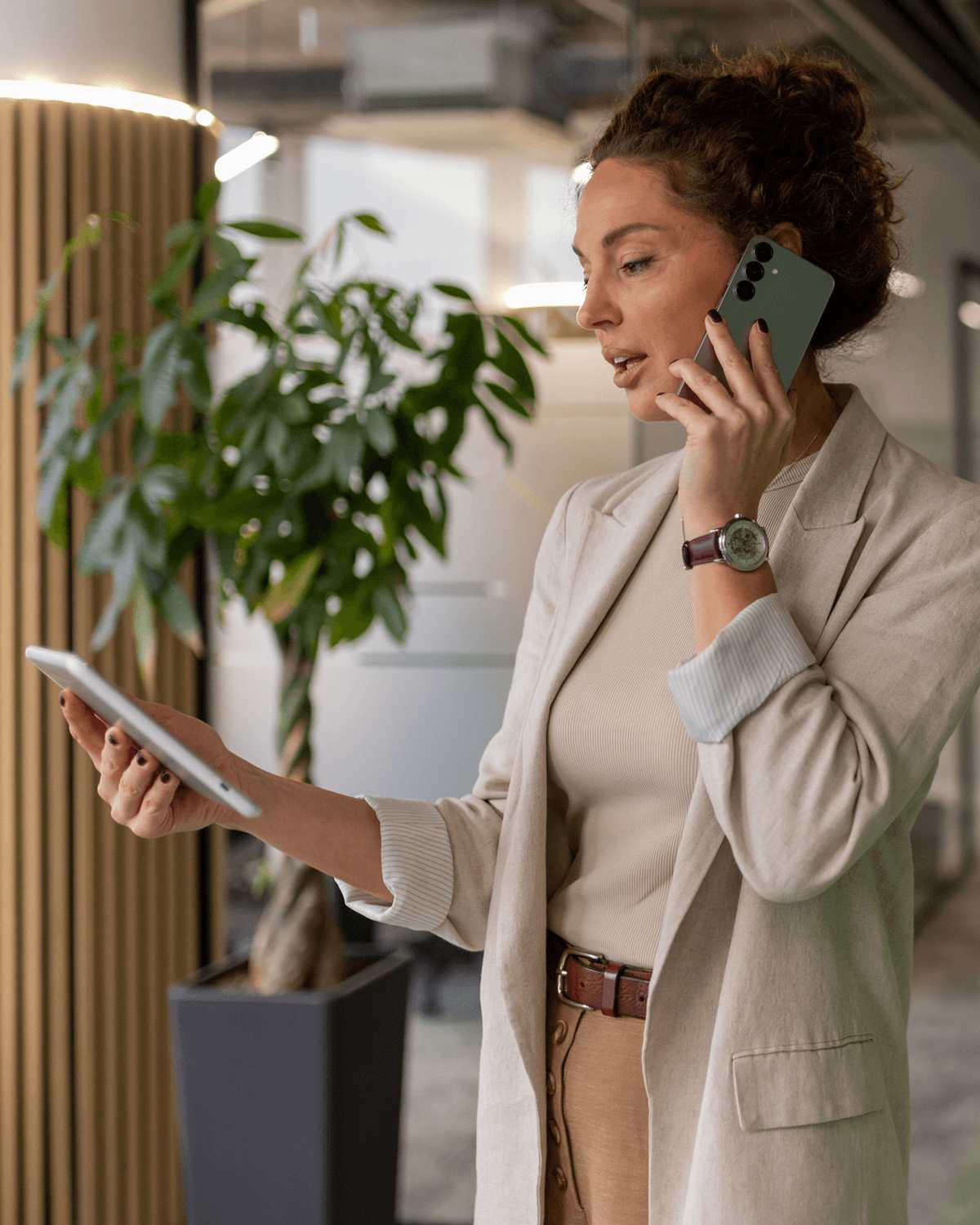 Real estate agent on a call with a seller, reviewing a lead on her tablet